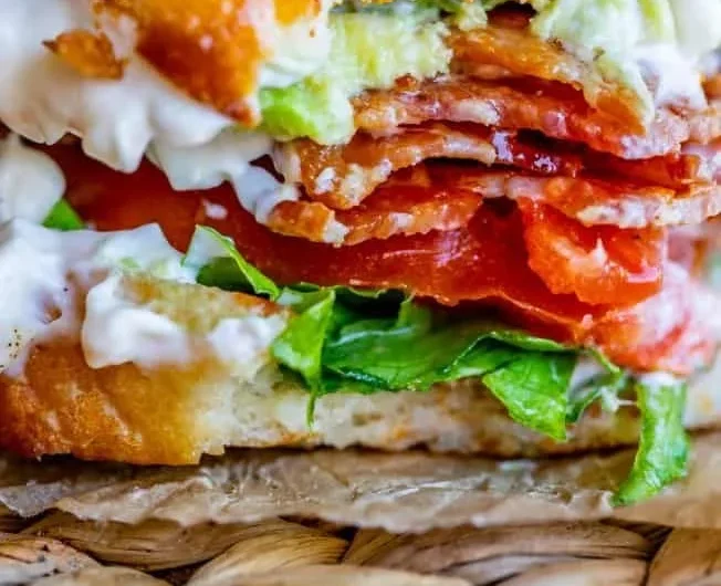 Avocado Bacon Lettuce and Tomato Sandwich served on a plate with fresh ingredients.