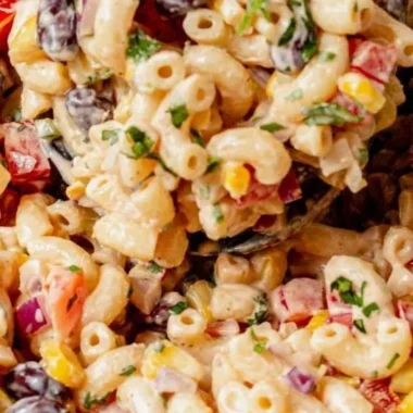 Bowl of colorful Mexican macaroni salad with fresh vegetables and lime dressing.