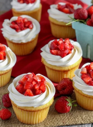 Delicious strawberry shortcake cupcakes topped with fresh strawberries and cream
