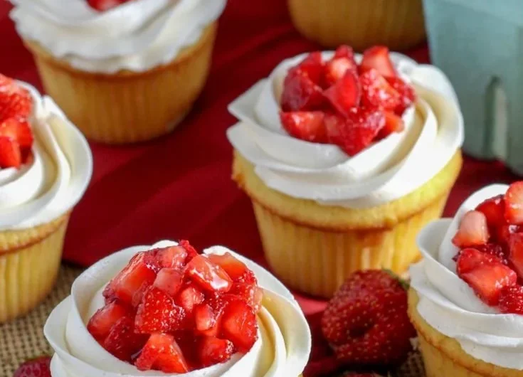 Delicious strawberry shortcake cupcakes topped with fresh strawberries and cream