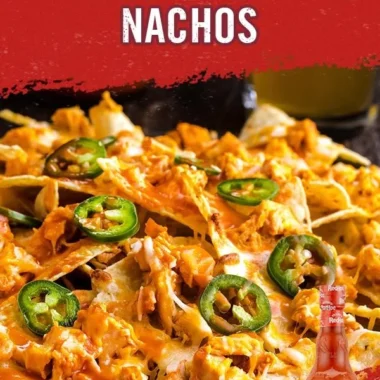 Plate of Buffalo Chicken Nachos topped with cheese and green onions