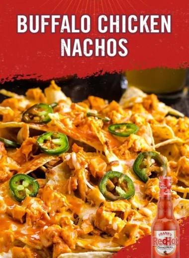 Plate of Buffalo Chicken Nachos topped with cheese and green onions