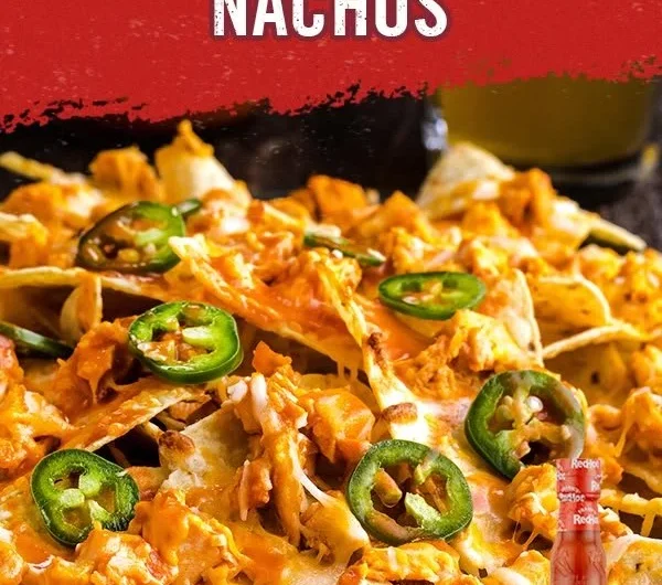 Plate of Buffalo Chicken Nachos topped with cheese and green onions