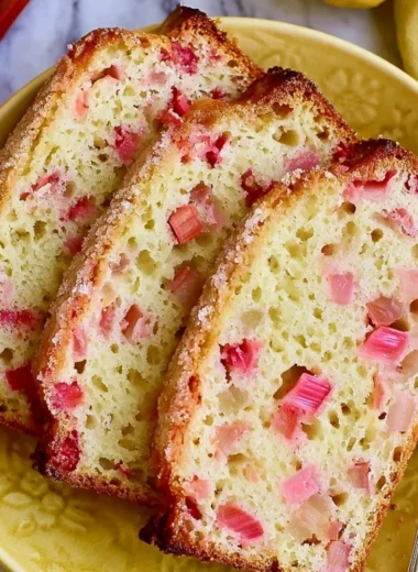 Sliced classic lemon rhubarb bread on a wooden board