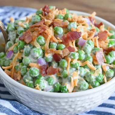 Classic pea salad with crispy bacon on a serving dish.