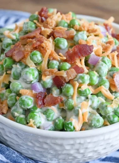 Classic pea salad with crispy bacon on a serving dish.
