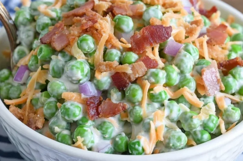 Classic pea salad with crispy bacon on a serving dish.
