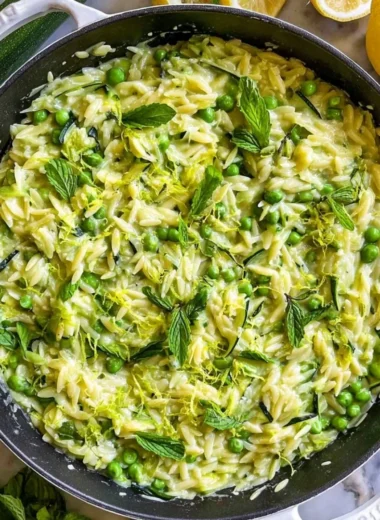 Plate of lemon orzo with zucchini garnished with fresh herbs