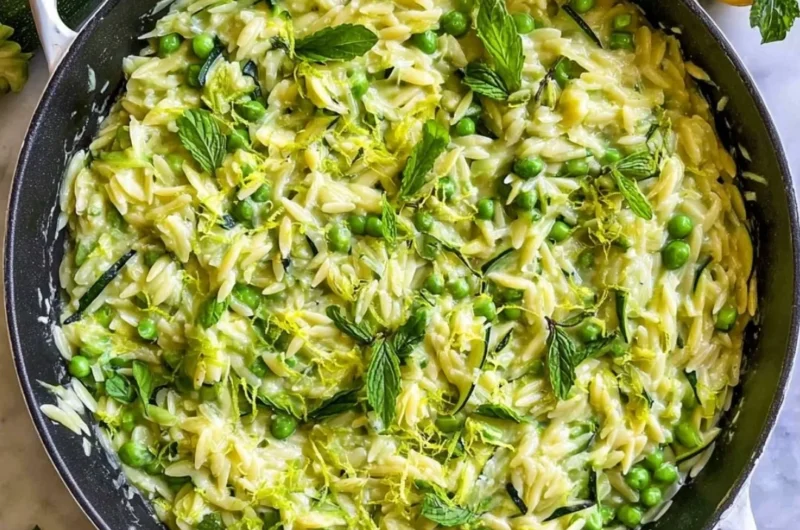 Plate of lemon orzo with zucchini garnished with fresh herbs