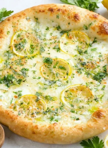 Lemon pizza topped with fresh herbs and cheese