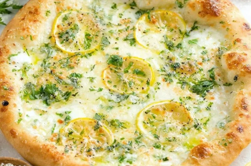 Lemon pizza topped with fresh herbs and cheese