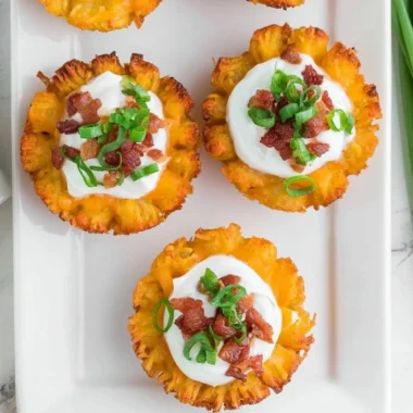 Loaded tater tots topped with cheese and bacon served on a plate