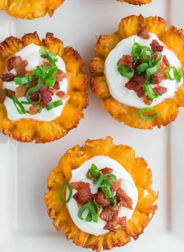 Loaded tater tots topped with cheese and bacon served on a plate
