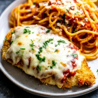 Oven baked chicken parmesan with cheese and marinara sauce on a plate