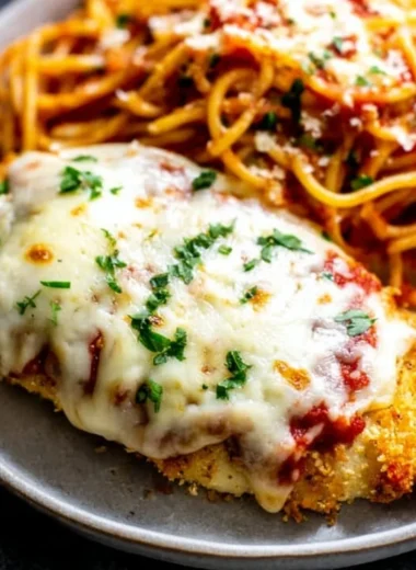 Oven baked chicken parmesan with cheese and marinara sauce on a plate