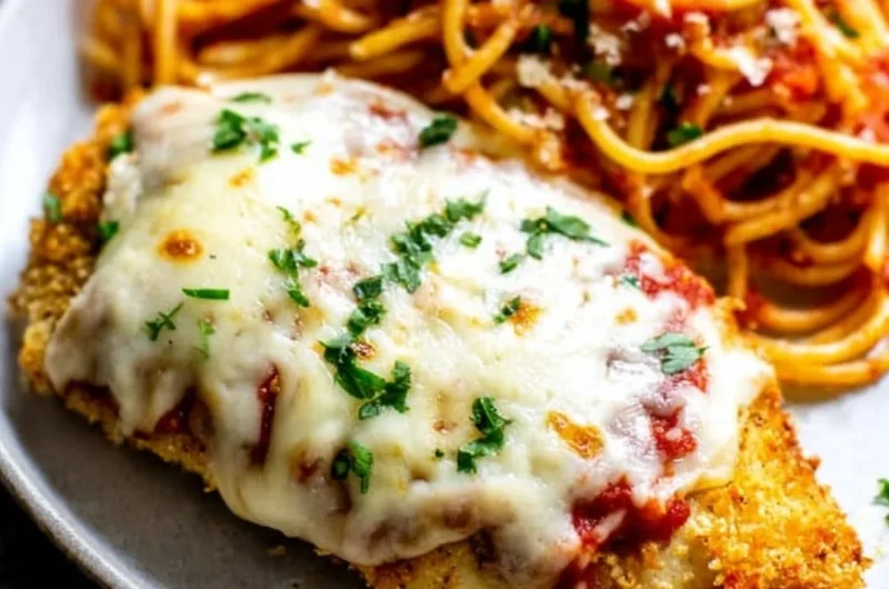 Oven baked chicken parmesan with cheese and marinara sauce on a plate