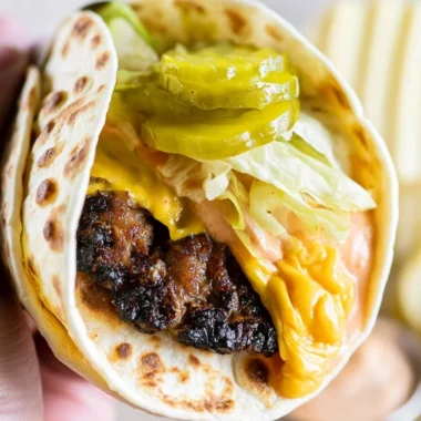 Delicious Smash Burger Taco served with burger sauce on a wooden platter.