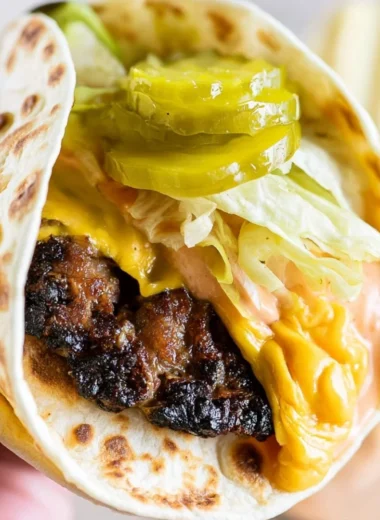 Delicious Smash Burger Taco served with burger sauce on a wooden platter.