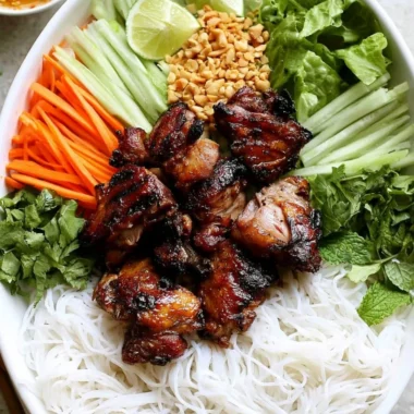 Vietnamese grilled pork rice noodle bowl topped with fresh herbs and vegetables.