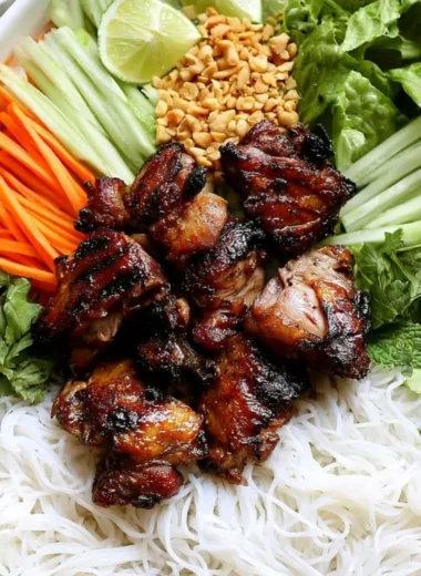 Vietnamese grilled pork rice noodle bowl topped with fresh herbs and vegetables.