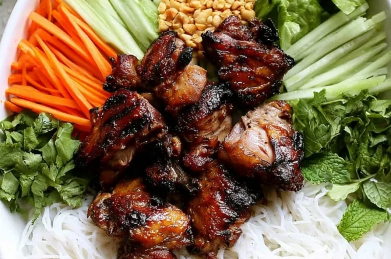 Vietnamese grilled pork rice noodle bowl topped with fresh herbs and vegetables.