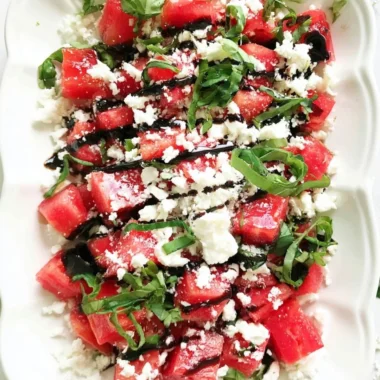 Watermelon salad with feta cheese on a plate garnished with mint leaves