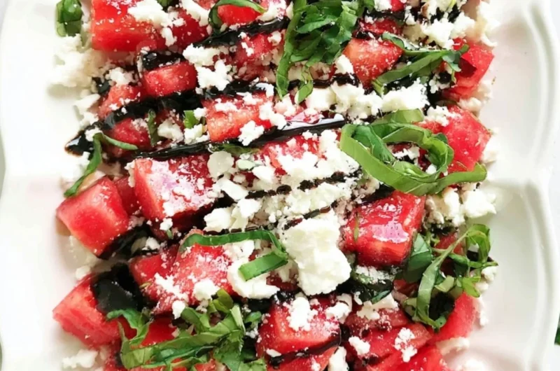 Watermelon salad with feta cheese on a plate garnished with mint leaves