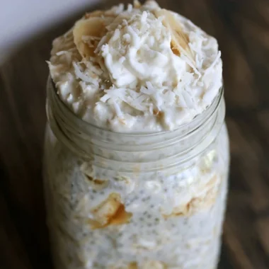 Healthy Banana and Coconut Overnight Oats in a glass bowl with toppings.