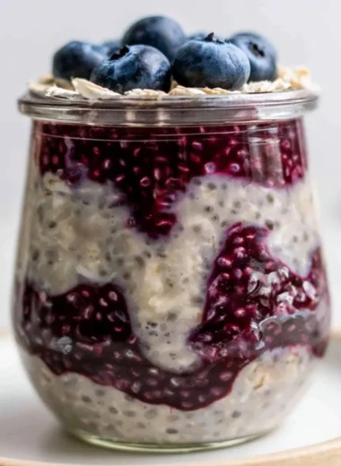 Bowl of blueberry overnight oats topped with fresh blueberries and almonds
