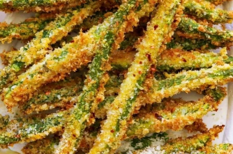 Crispy breaded air fryer asparagus served on a white plate.