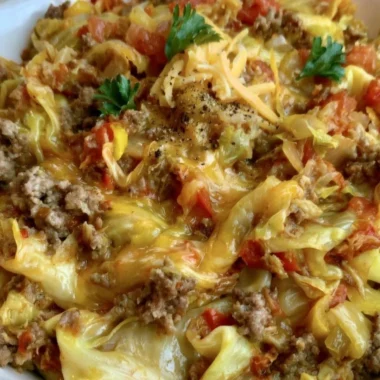 Delicious cabbage roll skillet served in a bowl with vibrant vegetables and sauce.
