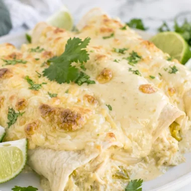 Delicious creamy white chicken enchiladas topped with cheese and cilantro