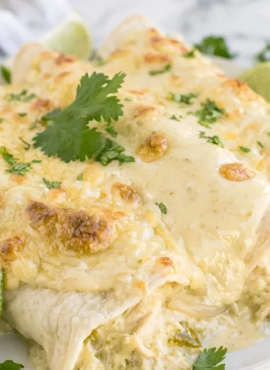 Delicious creamy white chicken enchiladas topped with cheese and cilantro
