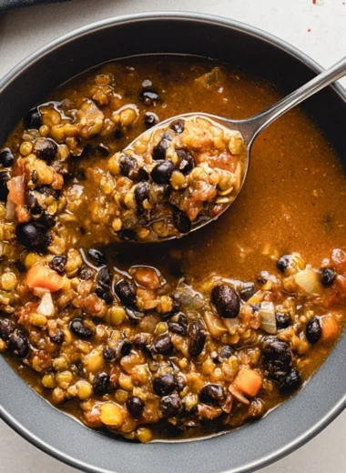 Bowl of protein-packed black bean and lentil soup topped with fresh herbs.