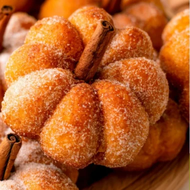 Cozy pumpkin donuts fresh out of the oven, topped with cinnamon sugar.