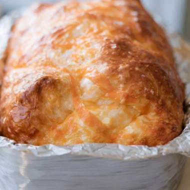 Freshly baked cozy sourdough cheese bread with melted cheese and crispy crust.