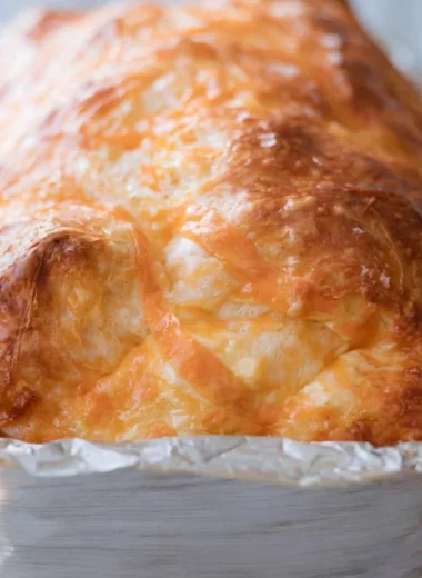 Freshly baked cozy sourdough cheese bread with melted cheese and crispy crust.