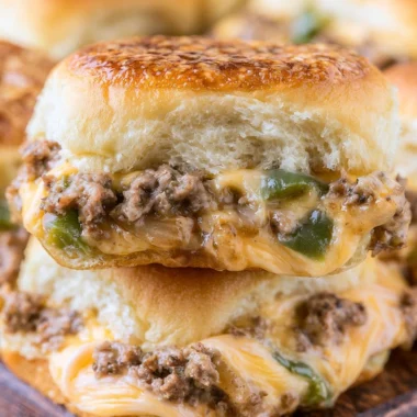 Philly Cheesesteak Sliders topped with melted cheese and sautéed onions