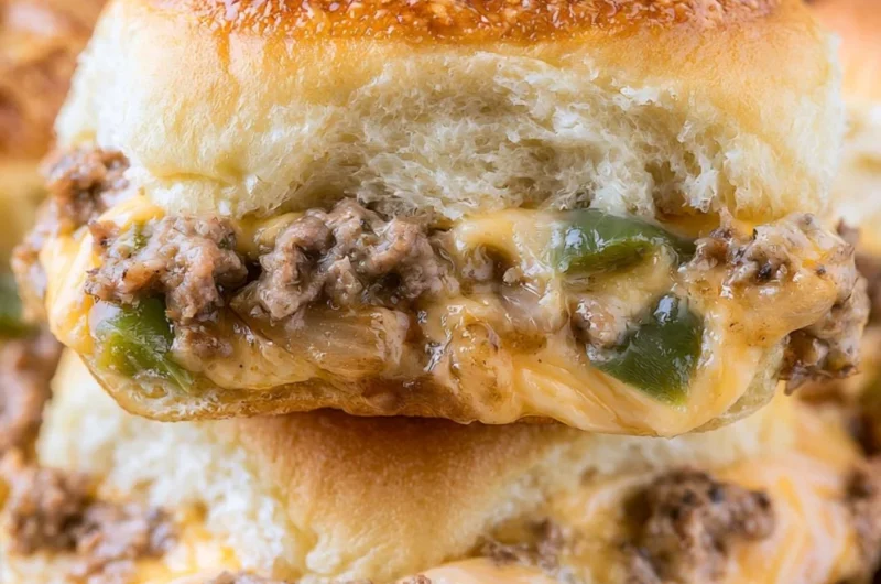 Philly Cheesesteak Sliders topped with melted cheese and sautéed onions
