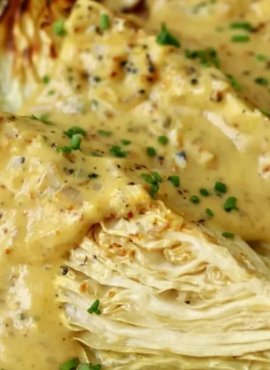 Roasted cabbage wedges drizzled with onion-Dijon sauce on a plate