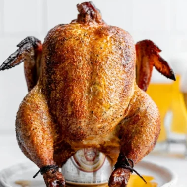 Delicious smoked beer can chicken on a grill with vibrant spices.