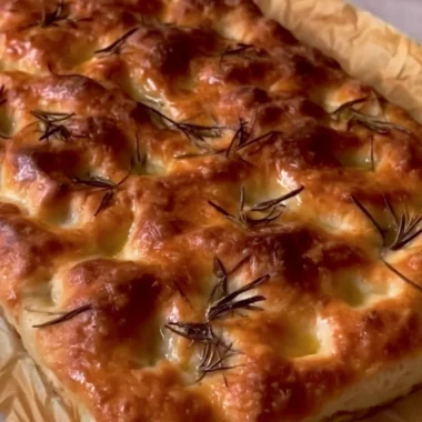 Freshly baked sourdough focaccia topped with herbs and olive oil