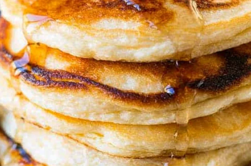 Plate of creamy ricotta pancakes topped with berries and syrup