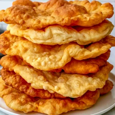 Freshly made warm fry bread served on a rustic wooden table.