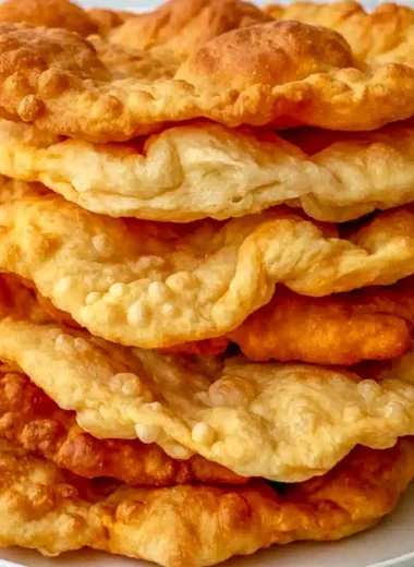 Freshly made warm fry bread served on a rustic wooden table.