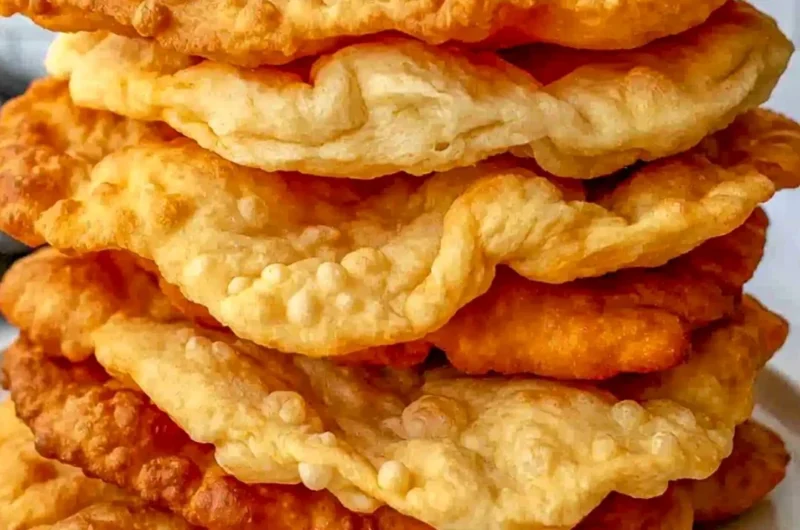 Freshly made warm fry bread served on a rustic wooden table.